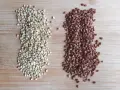 Dos montones de alforfón, uno verde y otro tostado, sobre una tabla de madera. ¿Alforfón que es? Un grano nutritivo.