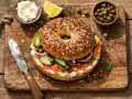 Bagel con salmón ahumado, queso crema, pepino, cebolla morada y alcaparras. Un desayuno delicioso, pero ten en cuenta las calorías del bagel.