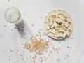 Tofu en cubos, leche de soja y semillas de soja. La nattokinase que es, se deriva de la soja fermentada.