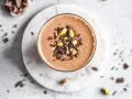 Batido de chocolate con pistachos y trozos de cacao, ideal como uno de los alimentos estimulantes para empezar el día.