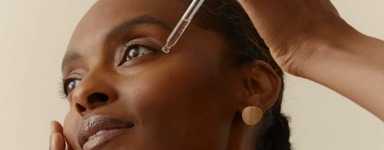 Una gota de sérum cae cerca del ojo de una mujer. Descubre la vitamina B6 para que sirve en la piel, un ingrediente clave para una piel radiante.
