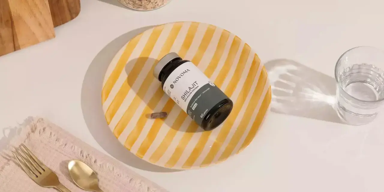 Un frasco de Shilajit y una cápsula sobre un plato rayado. Descubre para qué sirve el shilajit y cómo puede beneficiar tu sistema nervioso e inmunológico.
