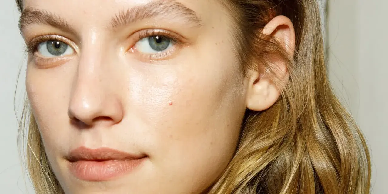 Rostro de mujer con piel luminosa y húmeda, como si acabara de usar bruma facial para que sirve la bruma facial, realzando su belleza natural.