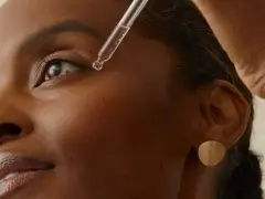 Una gota de sérum cae cerca del ojo de una mujer. Descubre la vitamina B6 para que sirve en la piel, un ingrediente clave para una piel radiante.