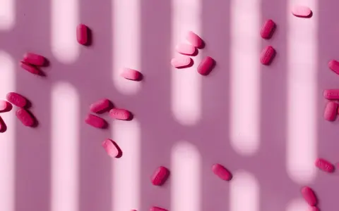Pastillas rosas esparcidas, algunas con la inscripción "44-329". ¿Paracetamol o ibuprofeno para la regla?