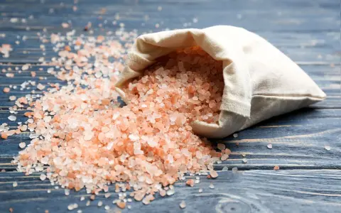 Sal del Himalaya derramada de una bolsa, con sus beneficios y contraindicaciones en mente.