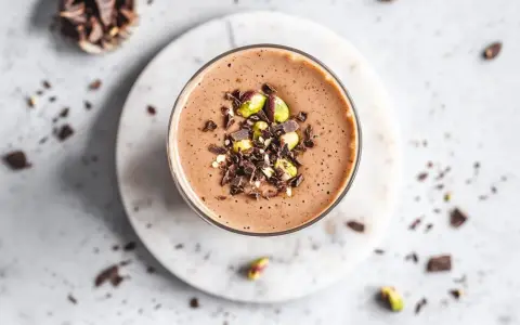 Batido de chocolate con pistachos y trozos de cacao, ideal como uno de los alimentos estimulantes para empezar el día.