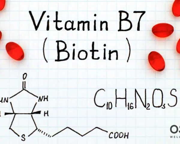 Biotina y embarazo: la vitamina B7, esencial para el desarrollo fetal, se muestra con su fórmula química y cápsulas rojas.