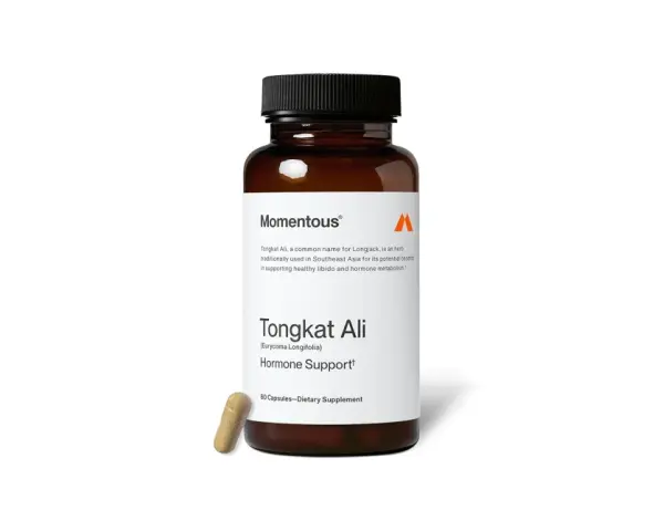 Frasco de suplemento Momentous con etiqueta "Tongkat Ali" para apoyo hormonal. Una cápsula yace al lado.