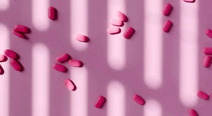 Pastillas rosas esparcidas, algunas con la inscripción "44-329". ¿Paracetamol o ibuprofeno para la regla?