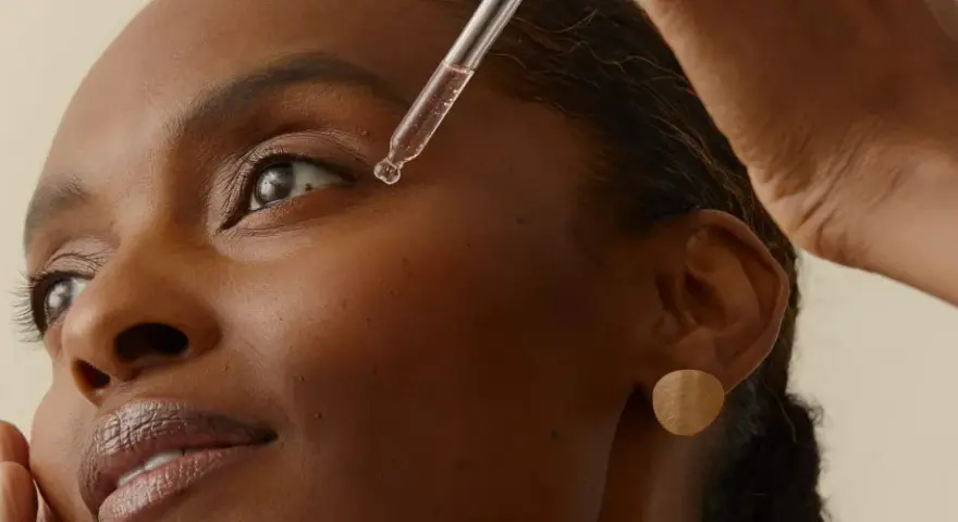 Una gota de sérum cae cerca del ojo de una mujer. Descubre la vitamina B6 para que sirve en la piel, un ingrediente clave para una piel radiante.