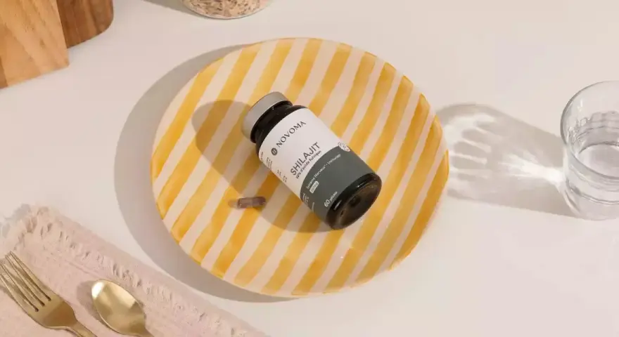 Un frasco de Shilajit y una cápsula sobre un plato rayado. Descubre para qué sirve el shilajit y cómo puede beneficiar tu sistema nervioso e inmunológico.