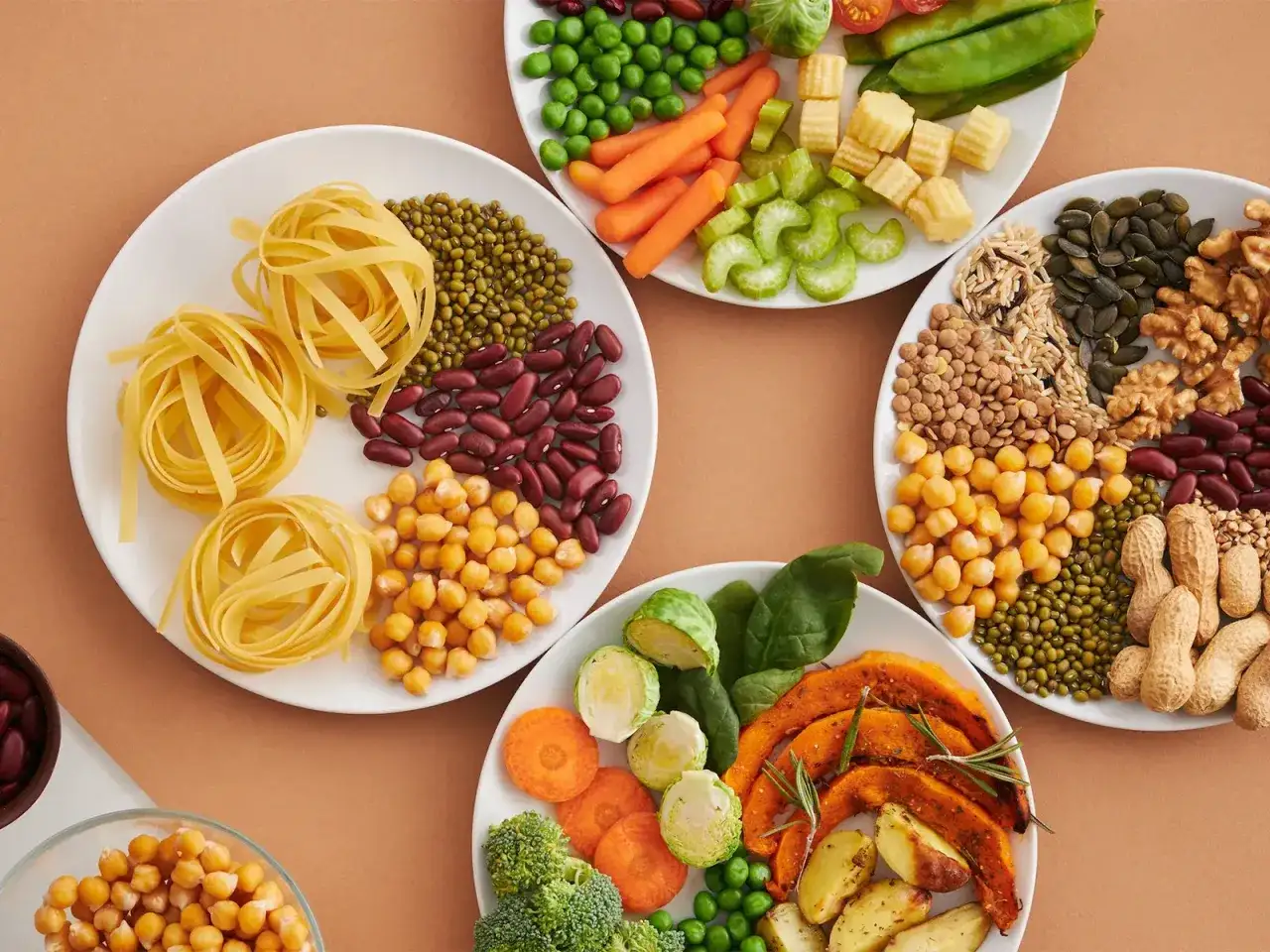 Platos llenos de alimentos con mucha fibra: pasta, frijoles, garbanzos, lentejas, nueces, semillas, br&oacute;coli, zanahorias, calabaza y m&aacute;s.
