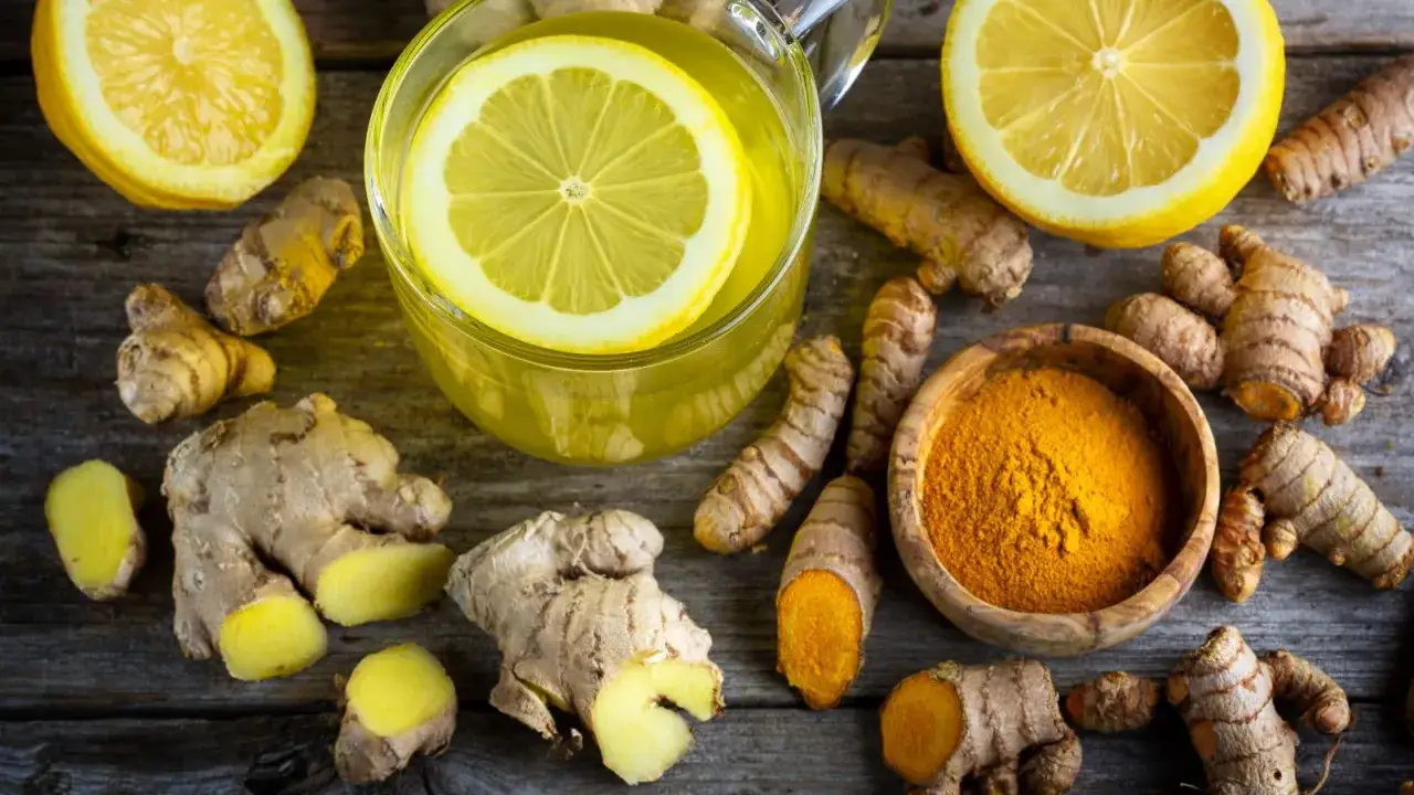 Infusión de jengibre y limón, con cúrcuma en polvo y raíces. Descubre los jengibre beneficios para la mujer.