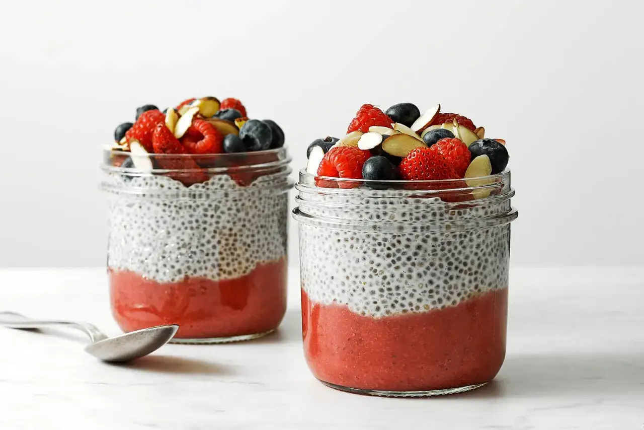 Dos frascos de pudín de chía con fresas y bayas, un desayuno lleno de chia proteinas y antioxidantes.